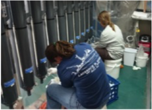 Jess Fitzsimmons, Amber Annett (of the Schofield group), and Laramie Jensen prepare for a deployment of the trace metal clean CTD/rosette. Right: Jess and Laramie filter trace metal samples from the Niskins in the trace metal clean “bubble”. 